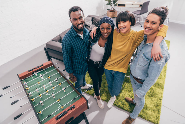 high angle view of multicultural friends standing near table football board  - 写真・画像