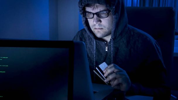 Retrato de jovem hacker masculino escrevendo código de programa para roubar dinheiro de cartões de crédito
 - Foto, Imagem