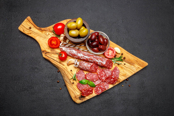 Dried organic salami sausage on wooden cutting board - Fotografie, Obrázek