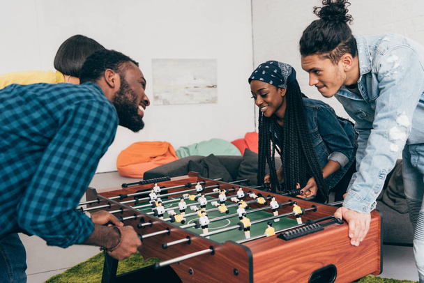 multicultural young friends playing table football  - Photo, Image