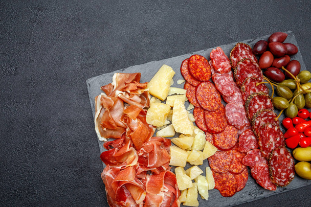Meat and cheese plate with salami sausage, chorizo, parma and parmesan cheese - Photo, image