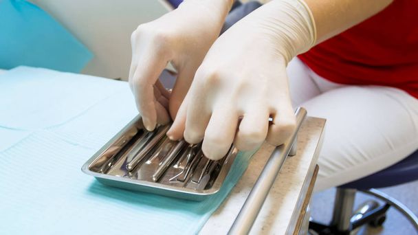 Closeup image of female dentist hand taking sterile tools - Valokuva, kuva