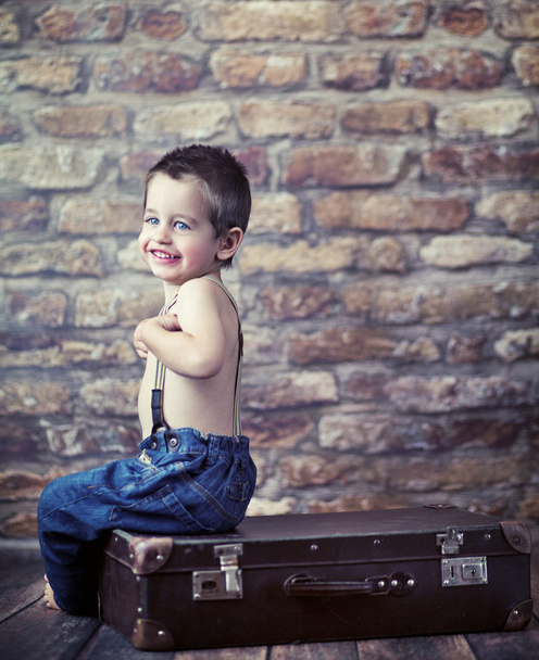 Small kid playing on the suitcase - Фото, зображення