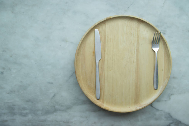 Vue de dessus, vaisselle vide fermée sur plateau en bois et place sur table en granit gris. Y compris fourchette, couteau et cuillère
. - Photo, image