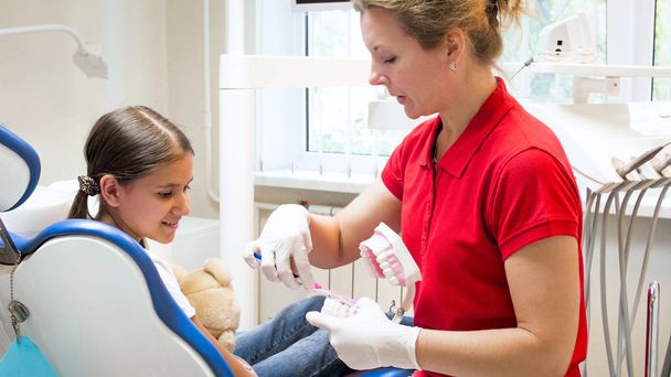 Portret van pediatrische tandarts laten zien hoe goed schoon tanden - Foto, afbeelding