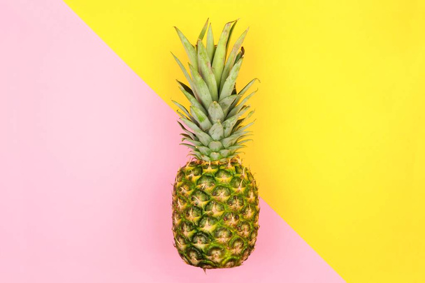 Ananas na moderní pastelové růžové a žluté úhlové pozadí. Minimální letní koncept. - Fotografie, Obrázek