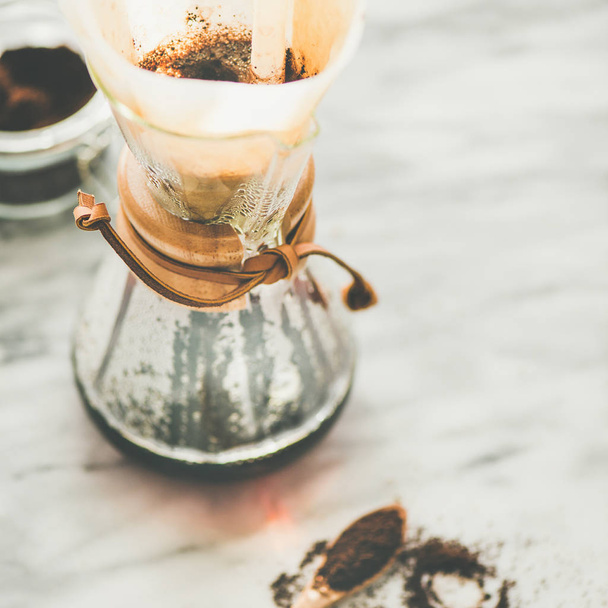 Morning black filtered coffee in glass flask on light grey marble table - Foto, imagen