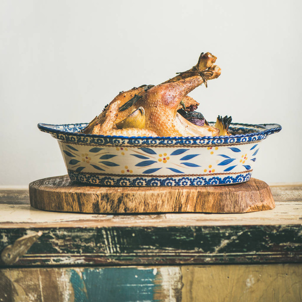 Roasted whole chicken for Christmas eve celebration table on rustic wooden board - Fotó, kép