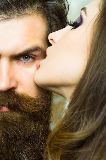 Bearded man with long beard kissed by woman. Bearded hipster and sensual woman. - 写真・画像