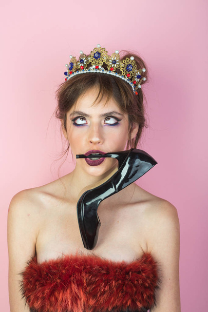queen. crown. A princess. Maleficent. Girl with a crown decorated with precious stones in studio on pink background. Dark lipstick. - Фото, изображение