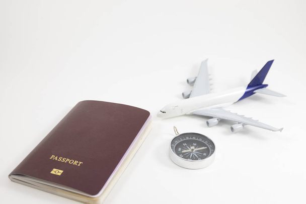 pasaporte de fondo blanco, comprass y avión modelo colocado en wh
 - Foto, Imagen