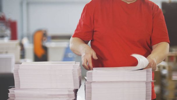 Female worker typography turning pages of a printed magazine - Photo, Image