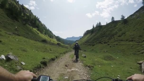 POV man riding e-bike following friend woman.Mtb action cyclist exploring together mountain trail path.Electrical bike active people sport travel vacation in Italy Alps outdoors in summer.4k video - Footage, Video