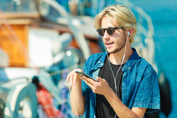 Homme blond en lunettes de soleil écoutant de la musique
 - Photo, image