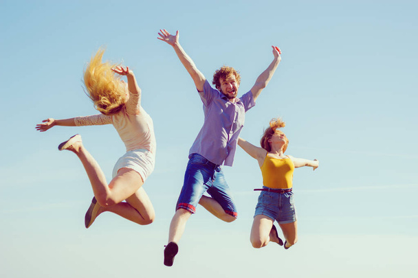 Group of friends boy two girls jumping outdoor - Foto, Imagem