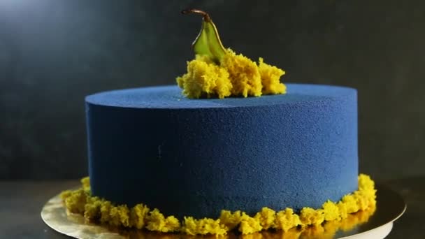deliziosa torta rotonda blu decorata con pere secche e pezzi di pan di Spagna giallo si muove veloce intorno a sé
 - Filmati, video