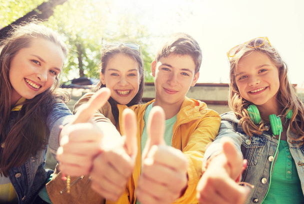 teenage friends or students showing thumbs up - Photo, Image
