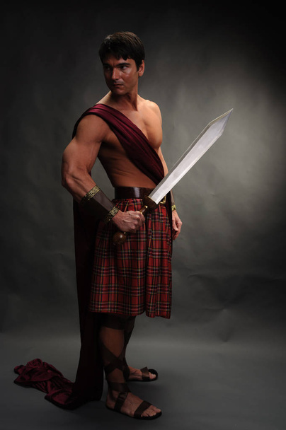 o belo highlander segura uma espada brilhante
 - Foto, Imagem