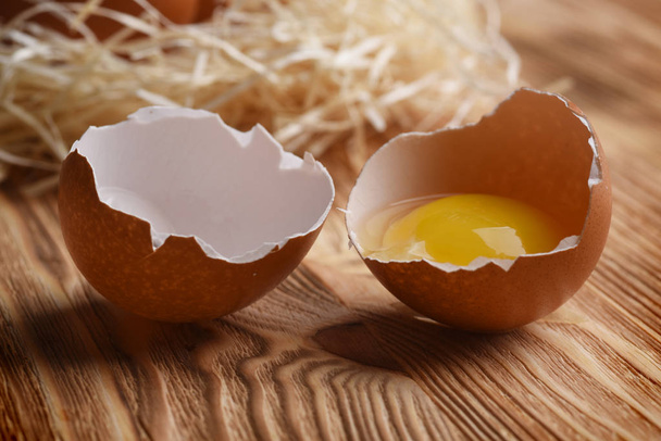 Näkymä rikki muna tuoretta keltuainen puinen tausta
 - Valokuva, kuva