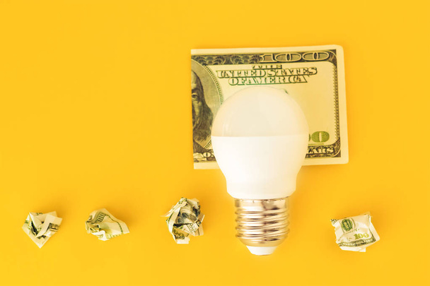Lampada a LED su banconota usd su sfondo giallo
 - Foto, immagini