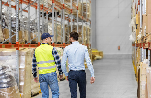 worker and businessman walking along warehouse - Фото, зображення