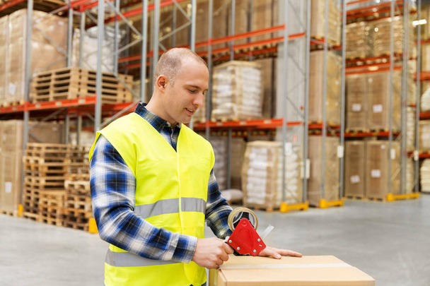 warehouse worker packing parcel with scotch tape - Photo, image