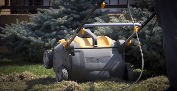 Κηπουρός που λειτουργεί μηχανή αερισμού εδάφους σε γρασίδι - Φωτογραφία, εικόνα