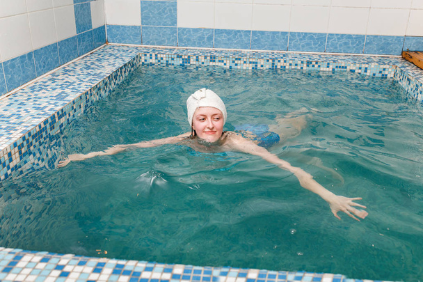женщина в погружение в закрытый бассейн, релаксации и закалки концепции тела
 - Фото, изображение