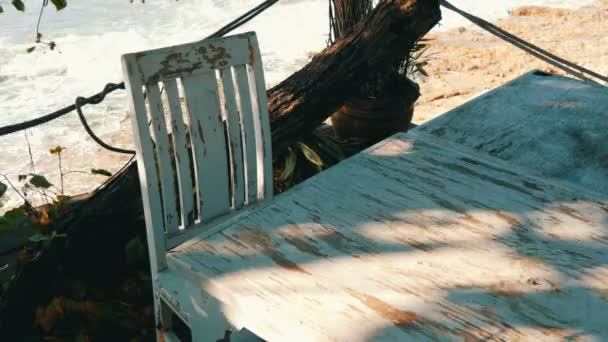 Café abandonado con sillas de madera blanca en la orilla del mar. Mesa de café en la playa
 - Imágenes, Vídeo