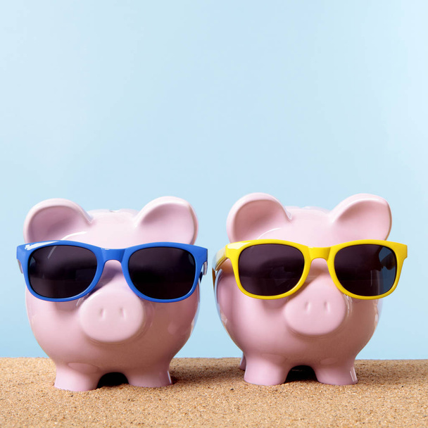 Two piggy banks beach sunglasses travel money saving - Photo, Image