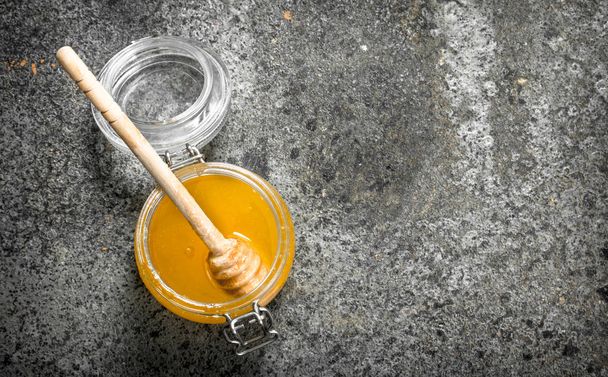 jar of fresh honey. On rustic background . - Фото, изображение