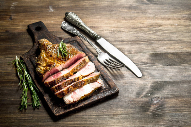 Beef grill with spices on a cutting Board. On a wooden table. - Photo, Image