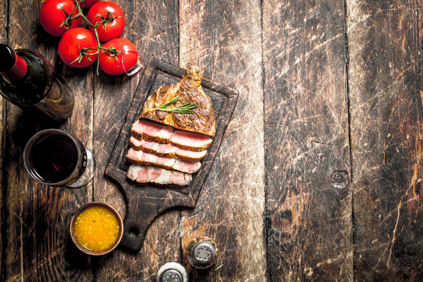Grilled beef steak with spices. On wooden background. - Fotó, kép