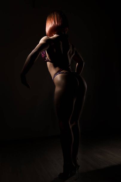 beautiful fitness woman, muscular girl poses on dark background. female body-building - Foto, Imagen