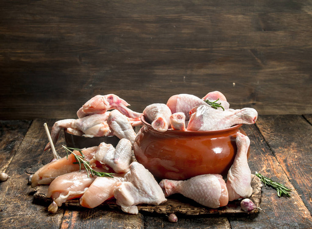 Various types of raw chicken meat with herbs in a bowl. On wooden background. - Φωτογραφία, εικόνα