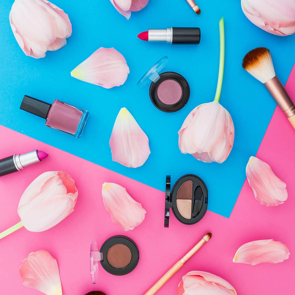 Bovenaanzicht van verschillende cosmetische producten met tulpen op levendige achtergrond - Foto, afbeelding