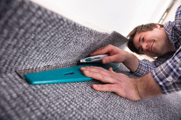 Male Carpet Fitter Installing Carpet With Cutter - Photo, image