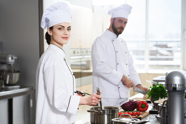Professional chefs working by stove on modern kitchen - Photo, Image