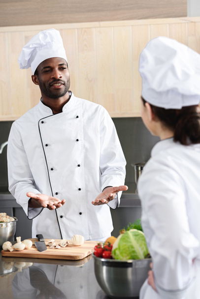 Équipe de chefs multiraciaux discutant recette et cuisine sur cuisine
 - Photo, image