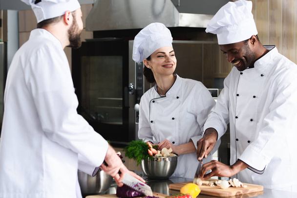 Équipe multiraciale de cuisiniers travaillant ensemble dans la cuisine du restaurant
 - Photo, image