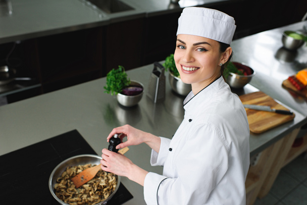 vista de ángulo alto de atractivos champiñones especias chef en la sartén en la cocina del restaurante
 - Foto, Imagen