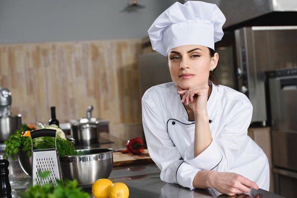 aantrekkelijke peinzende chef-kok camera bij restaurant keuken kijken - Foto, afbeelding