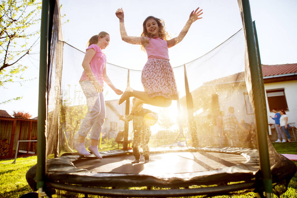  tres adorables niños juguetones saltando en trampolín al aire libre
  - Foto, imagen