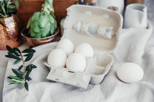 Still life in Rustic style fresh eggs, milk, artichoke on linen table. Organic eco farm products - Fotoğraf, Görsel
