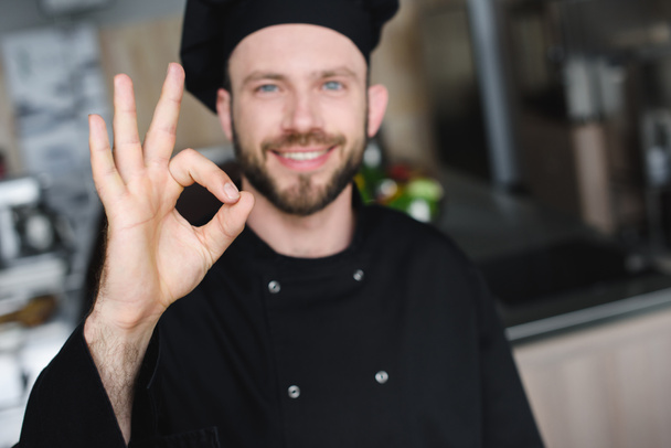 sonriente guapo chef mostrando ok gesto en restaurante cocina
 - Foto, imagen