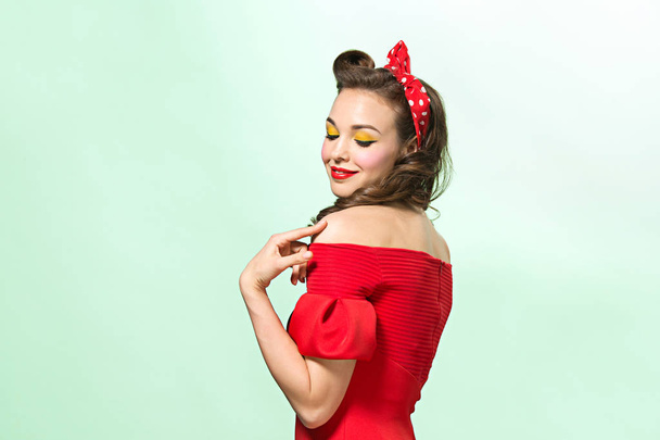 Beautiful young woman with pinup make-up and hairstyle. Studio shot on white background - Foto, imagen