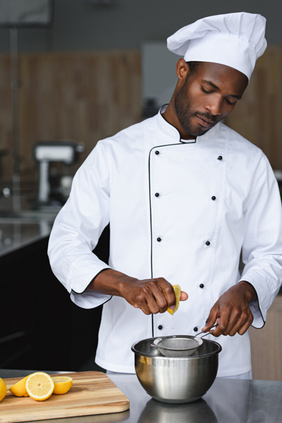 beau chef afro-américain serrant des citrons à la cuisine du restaurant
 - Photo, image