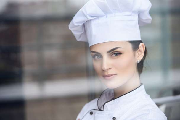 atractivo chef mirando a la cámara en la cocina del restaurante
 - Foto, Imagen