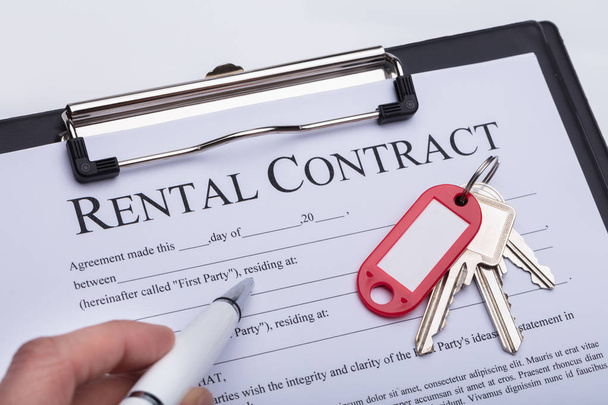 Gros plan de la clé sur le formulaire de contrat de location de main d'une personne
 - Photo, image
