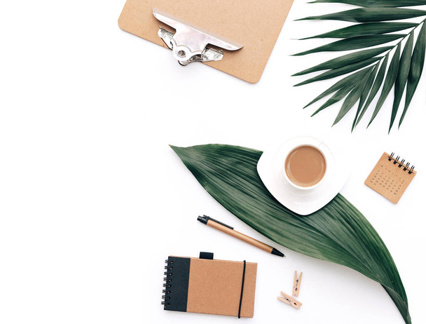 Table de bureau minimaliste avec ensemble de papeterie, fournitures et feuilles de palmier. Vue du dessus avec espace de copie, plan créatif
. - Photo, image